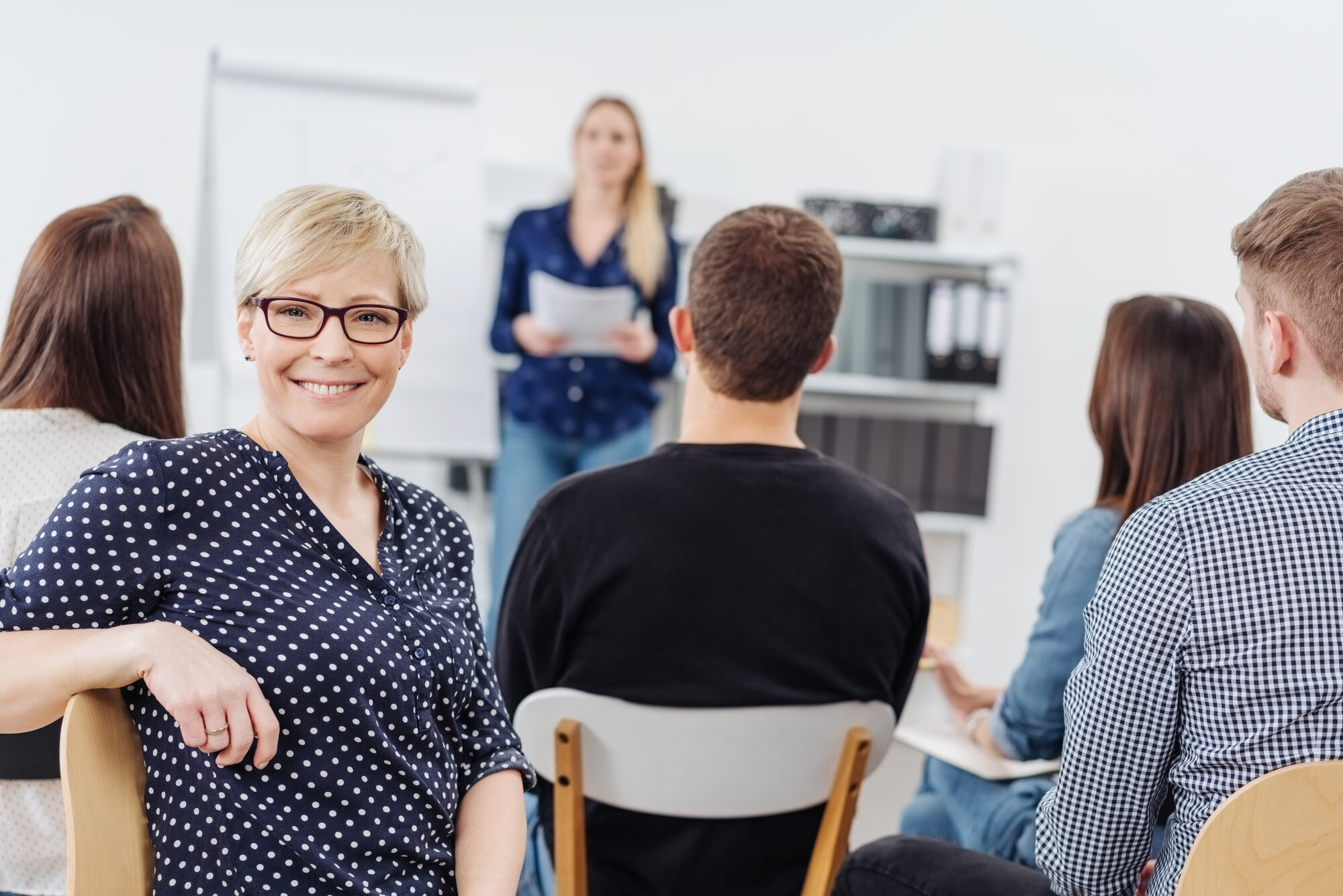 Woman smiling at camera during office meeting